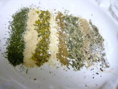 four different types of spices on a white plate