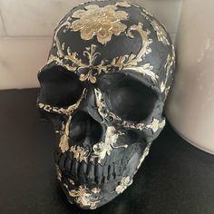 a black and gold skull sitting on top of a table