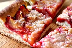 slices of strawberry crumb pizza sitting on top of a wooden cutting board