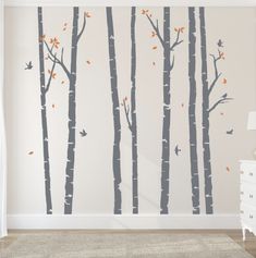 a bedroom with white walls and trees painted on the wall