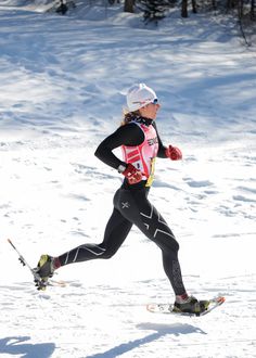 a woman is running in the snow on skis