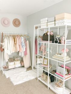 a white closet filled with lots of clothes and shoes next to a wall mounted shelf