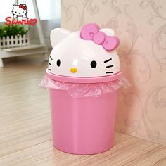 a pink trash can with a hello kitty head on it's lid sitting next to a wall