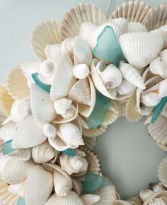 a wreath made out of seashells is hanging on the wall