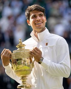 a male tennis player holding up a trophy