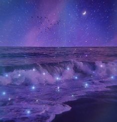 the sky is filled with stars above the ocean