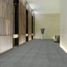 an empty room with two vases on the wall and carpeted flooring in front of it