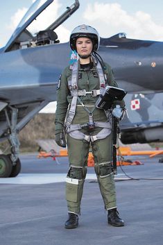 a man standing in front of an air force jet with helmet and goggles on