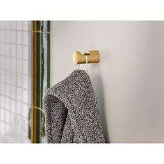 a coat hanging on the wall next to a towel rack