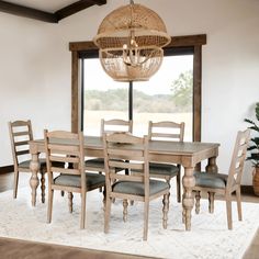 a dining room table with six chairs and a chandelier hanging from the ceiling