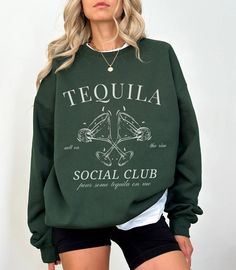 "Elevate your style with our exclusive Tequila-themed sweatshirt from Lavender Maple! This cozy crewneck sweater features a striking black and white design, showcasing the word \"Tequila\" in a bold varsity font on the front. Perfect for tequila enthusiasts and fashion-forward individuals alike, this statement piece not only keeps you warm but also adds a touch of vibrant personality to your wardrobe. Indulge in the comfort of this high-quality sweatshirt while expressing your love for tequila in a fashionable way. Ideal for casual outings, gatherings, or simply lounging at home with a drink in hand. Make a bold statement with our Tequila Sweatshirt and let your style speak volumes. Explore the intersection of comfort and fashion with Lavender Maple's exclusive apparel collection. Shop now Expresso Martini, Luxury Bachelorette, Vodka Martini, Cocktail Club, Club Sweatshirts, Dirty Martini, Espresso Martini, Signature Cocktail, Girls Club