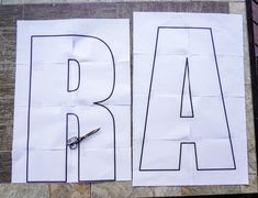 two pieces of paper cut into the shape of letters with scissors next to each letter