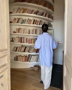 a person standing in front of a book shelf filled with books