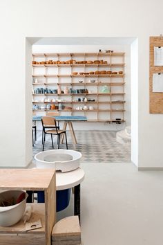 a room with several shelves and chairs in it, including a bowl on the table