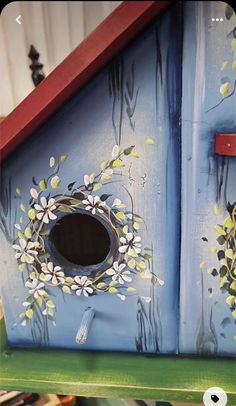 a bird house painted with flowers and leaves