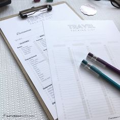 two pens are sitting on top of a travel checklist next to a pair of eyeglasses