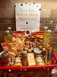 a red basket filled with lots of food next to a sign that says you are worth more than gold