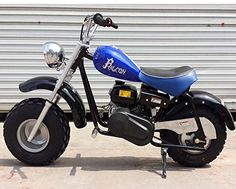 a blue and black motorcycle is parked in front of a building with a metal door