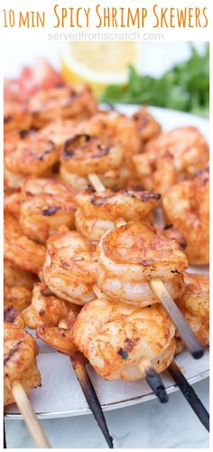 grilled shrimp skewers on a plate with lemon wedges