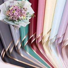 a bunch of different colored papers with flowers on them