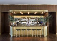 a man standing behind a bar with stools