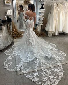 a woman is looking at her wedding dress in the mirror