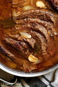 a pot filled with meat and onions on top of a table