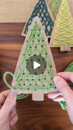 someone is making a christmas tree decoration out of string and yarns on a wooden table