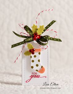 a christmas ornament hanging from a string on top of a white tablecloth