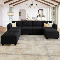 a living room with a large black sectional couch