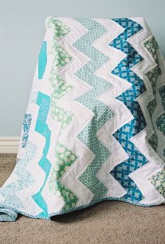 a blue and white quilt sitting on the floor