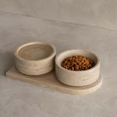 two bowls with food in them sitting on a table