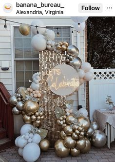 a bunch of balloons that are in front of a house with the words let's celebrate written on it