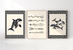 three framed art pieces depicting whales and arrows on white wall with polka dot border around them