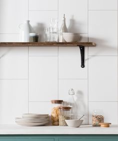 the shelves above the kitchen counter are filled with dishes and bowls, including glassware