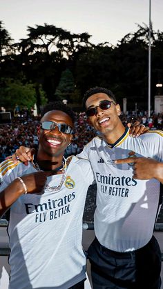 two men standing next to each other in front of a crowd