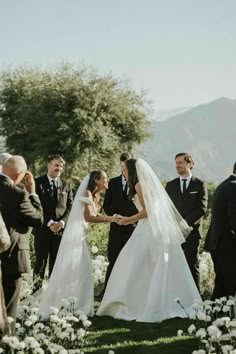 a bride and groom holding hands during their wedding ceremony