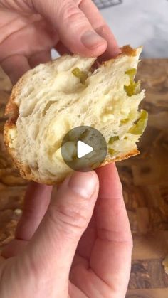 a person is holding a piece of bread with olives on it and there is a video showing how to make an appetizer