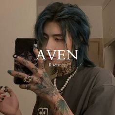 a man with blue hair and piercings is looking at his cell phone