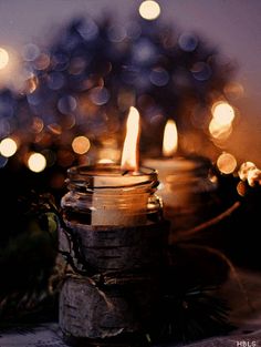 three lit candles sitting on top of a table