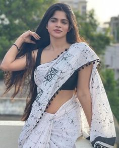 a woman in a white sari posing for the camera