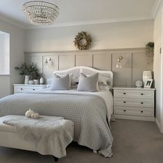 a bedroom with a large bed and white furniture