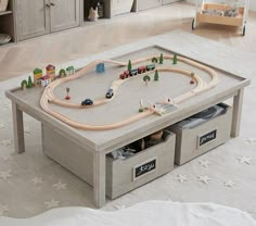 a child's toy train table with drawers on the bottom and cars on top