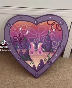 a purple heart shaped box with an image of two unicorns in the middle and under it