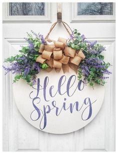 a welcome spring door hanger with purple flowers and burlap bow on it