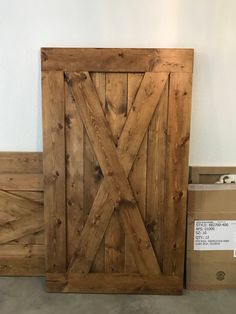 a wooden door sitting on top of a floor next to a box and some boxes