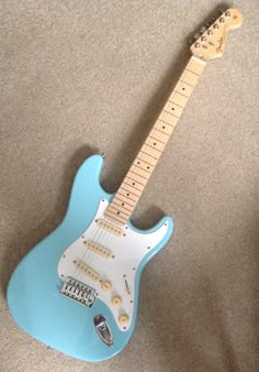 a blue guitar sitting on top of a carpet