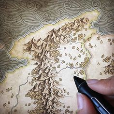 someone is drawing a map on paper with a pen