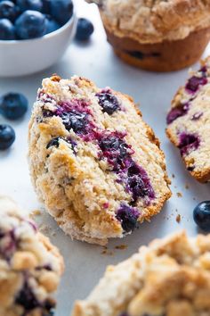 muffins with blueberries are on a white surface