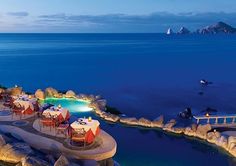 an aerial view of the resort at night with lights on and water in the foreground